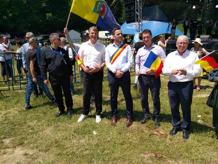 Menschen mit Deutschland und Rumänienflaggen.