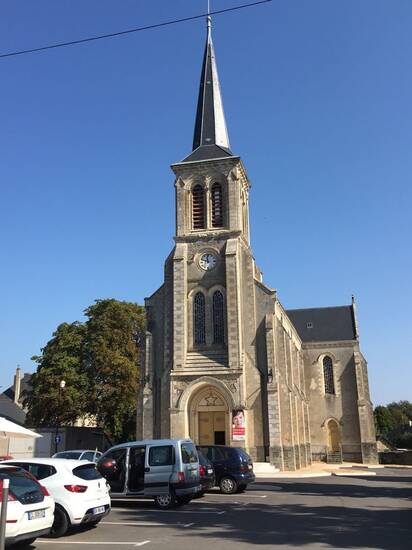 Eine Kirche in Meslay du Maine bei blauem Himmel und Sonnenschein.