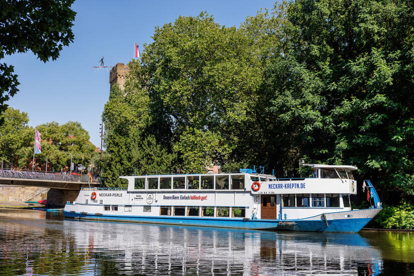 Schiff auf dem Fluss Neckar, im Hintergrund Bäume.