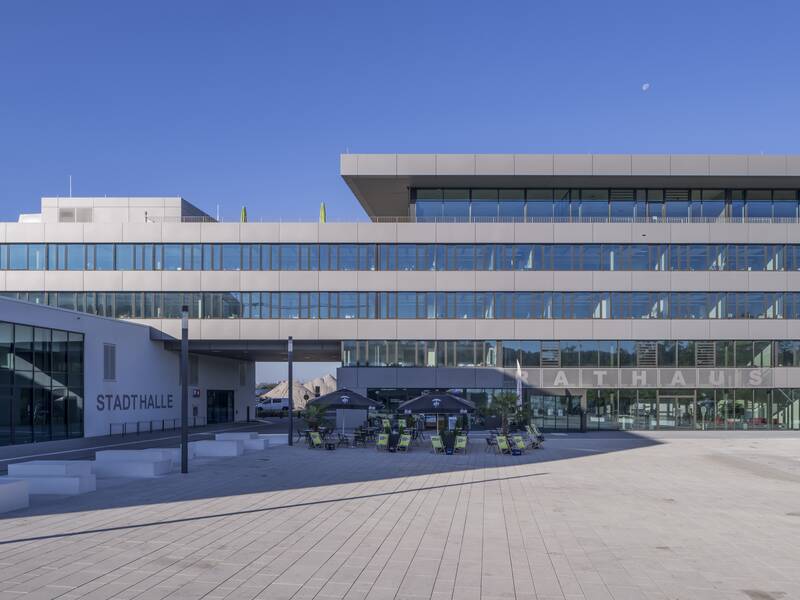 Rathaus und Stadthalle als Gebäude mit dem Vorplatz vor blauem Himmel