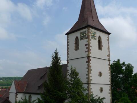 Kirche mit Kirchturm bei blauem Himmel.