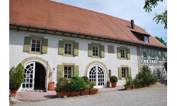 Alte Gemeindehalle Hochberg von außen bei sonnigem Wetter und blauem Himmel.