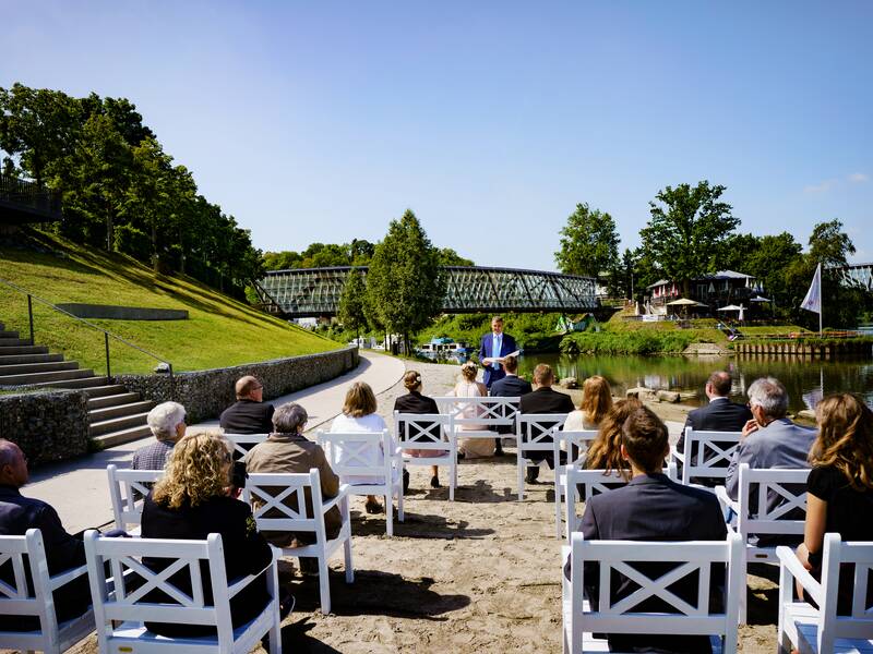 Menschen auf Stühlen am Neckarstrand.