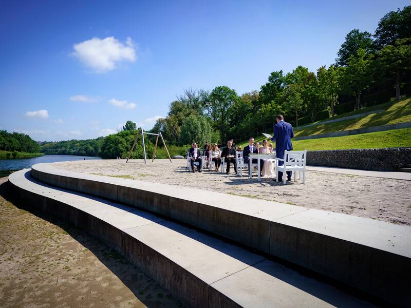 Neckarstrand mit festlich gekleideten Menschen.