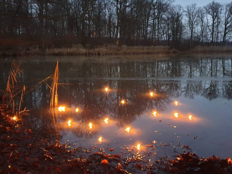 See bei Dämmerung mit mystischen Lichtern unter der Wasseröberfläche